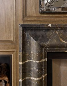 a marble fireplace surround with wood paneling