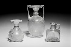 three glass vases sitting next to each other on a table