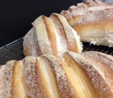 several loaves of bread sitting on top of a cooling rack with powdered sugar