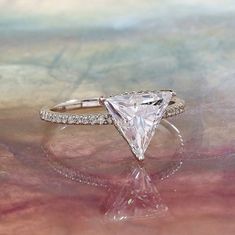 a white diamond ring sitting on top of a table