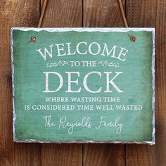 a welcome sign hanging on the side of a wooden fence that says, welcome to the patio