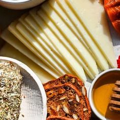 several different types of cheeses and sauces are arranged on a table with other foods