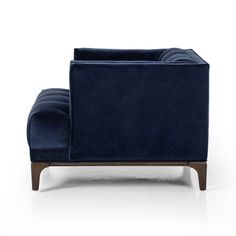 a blue couch sitting on top of a white floor next to a wooden leg chair