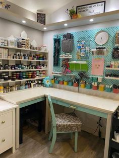 the inside of a craft shop with lots of supplies on shelves and desks in front of it