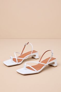 The Intentionally Blank Fifi Ice White Leather Strappy Slingback Low Heel Sandals pair to perfection with warm sunny days! Smooth genuine leather shapes these effortlessly chic sandals that feature a square footbed and a thong-style upper that flows into an asymmetrical strappy vamp. A trendy slingback strap sprouts from the sides and secures at the outstep with a shiny silver buckle. A low, slender block heel completes the coveted look! Available in Euro sizes only. 1. 25" wrapped block heel. C Chic Slingback Pumps With Ankle Strap For Summer, Chic Summer Slingback Pumps With Ankle Strap, Chic Summer Slingback Pumps With Block Heel, Chic Summer Slingback Heels, Chic Summer Slingback Pumps With Open Heel, Chic Summer Slingback Pumps With Wrapped Heel, Summer Slingback Pumps With Block Heel And Strap, Summer Block Heel Slingback Pumps With Strap, Summer Ankle Strap Slingback Sandals With Branded Heel