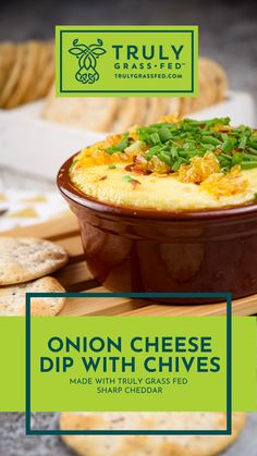 an onion cheese dip with chives in a bowl next to crackers