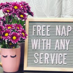 a pink vase filled with purple flowers next to a sign that says free nap with any service