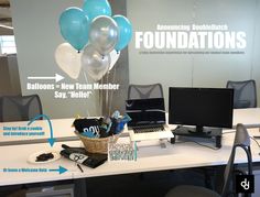 an office desk with balloons and other items on it, including a desktop computer monitor