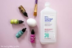 the contents of a beauty product on a pink background with bottles and other items around it