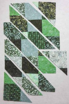 a piece of green and black quilted material with white strips in the shape of rectangles