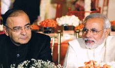 two men sitting next to each other at a table with flowers in front of them