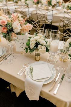 the table is set with white and pink flowers