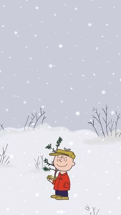 a little boy holding a small tree in the snow