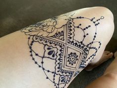 a woman's leg with a tattoo design on the back of her arm and legs