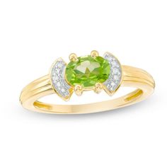 a yellow gold ring with an oval cut green and white diamond set in the center