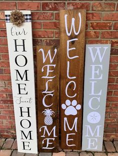 three wooden signs that say welcome, welcome home and welcome to the dog with paw prints on them