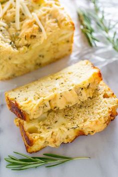 two slices of bread with cheese and herbs on top, sitting next to each other