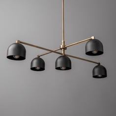 four lights are hanging from a brass and black chandelier