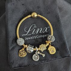 a bracelet with charms on it sitting on a black velvet bag that says lmx jewelry company