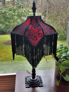 a red and black lamp sitting on top of a wooden table