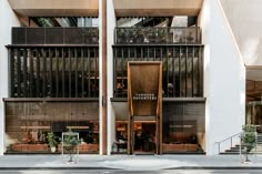 two cars parked in front of an apartment building with balconies on the second floor