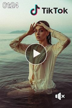 a woman sitting in the water with her hands on her head