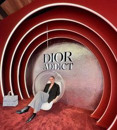 a woman is sitting in a chair on the red carpet