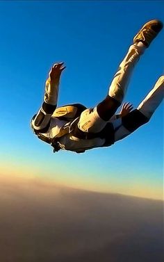 a man flying through the air on top of a parachute