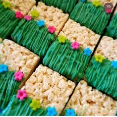 rice krispy treats are arranged in rows on a plate with blue and green frosting