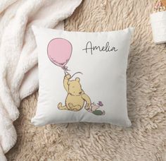 a winnie the pooh pillow with a pink balloon attached to it