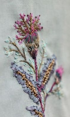 a close up of a flower embroidered on a piece of cloth