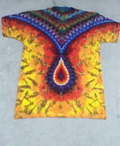 a tie - dyed t - shirt with an orange, yellow and blue design on it