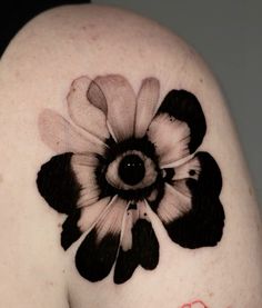 a close up of a person's shoulder with a flower tattoo on the side