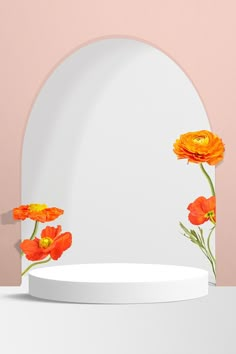 three orange flowers are on the edge of a round white table with a pink wall in the background