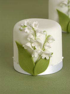 two cakes decorated with white flowers and green leaves