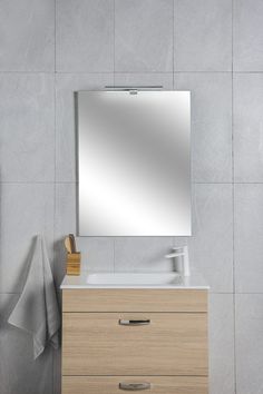 a bathroom vanity with a mirror above it and a towel hanging on the wall next to it