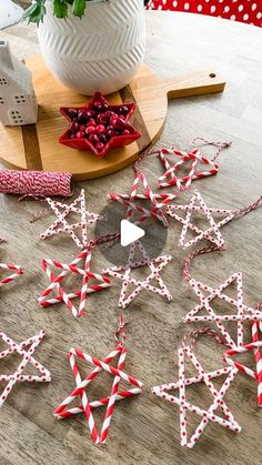 some red and white paper stars on a wooden table next to a potted plant