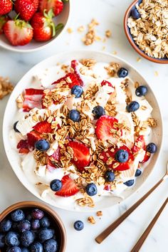 yogurt with berries and granola on a white table