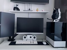 a computer desk with two monitors, keyboard and mouse on it's side in front of a wall mounted monitor