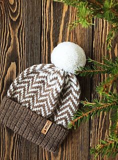 a brown and white hat sitting on top of a wooden table next to a pine tree