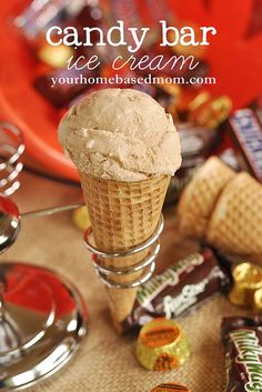 a scoop of ice cream sitting on top of a table next to some candy bars