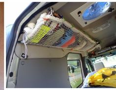 the inside of a van with various items in it's cargo net on the back