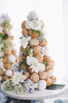 there is a small christmas tree made out of donuts and flowers on the table