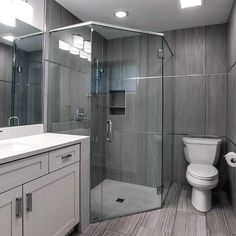 a bathroom with a toilet, sink, and shower stall is shown in this image