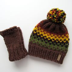 a knitted beanie and mitten sitting next to each other