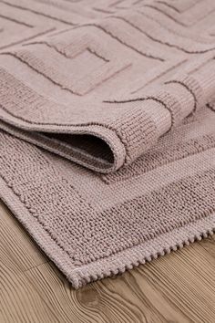 a close up of a rug on the floor with wood floors in the foreground