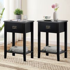 two black end tables sitting on top of a rug next to a vase with flowers