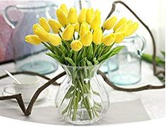 a vase filled with yellow flowers on top of a table