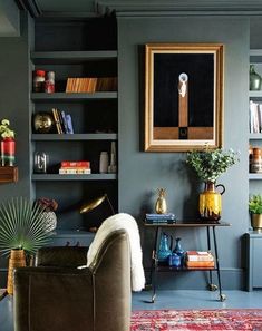 a living room filled with furniture and bookshelves next to a painting on the wall