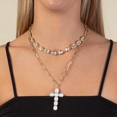 The Layered Cross Necklace is a stunning accessory that adds a touch of elegance and faith to any outfit. Its intricate design and sparkling crystal charms will surely catch the eye of anyone who sees it. Elevate your style and showcase your devotion with this must-have piece of jewelry. Rhinestone Accents Longest Chain - 24" in Length Warning: Lighting and screen resolutions may vary. Gold Crystal Rhinestone Cross Pendant Necklace, White Crystal Necklace With Rhinestones, White Crystal Cross Necklaces, White Crystal Rhinestone Necklaces, White Crystal Rhinestone Jeweled Necklace, White Crystal Jewelry With Pearl Charm, White Crystal Embellished Metal Jewelry, Spiritual White Crystal Jewelry, White Crystal Cross Pendant Necklace